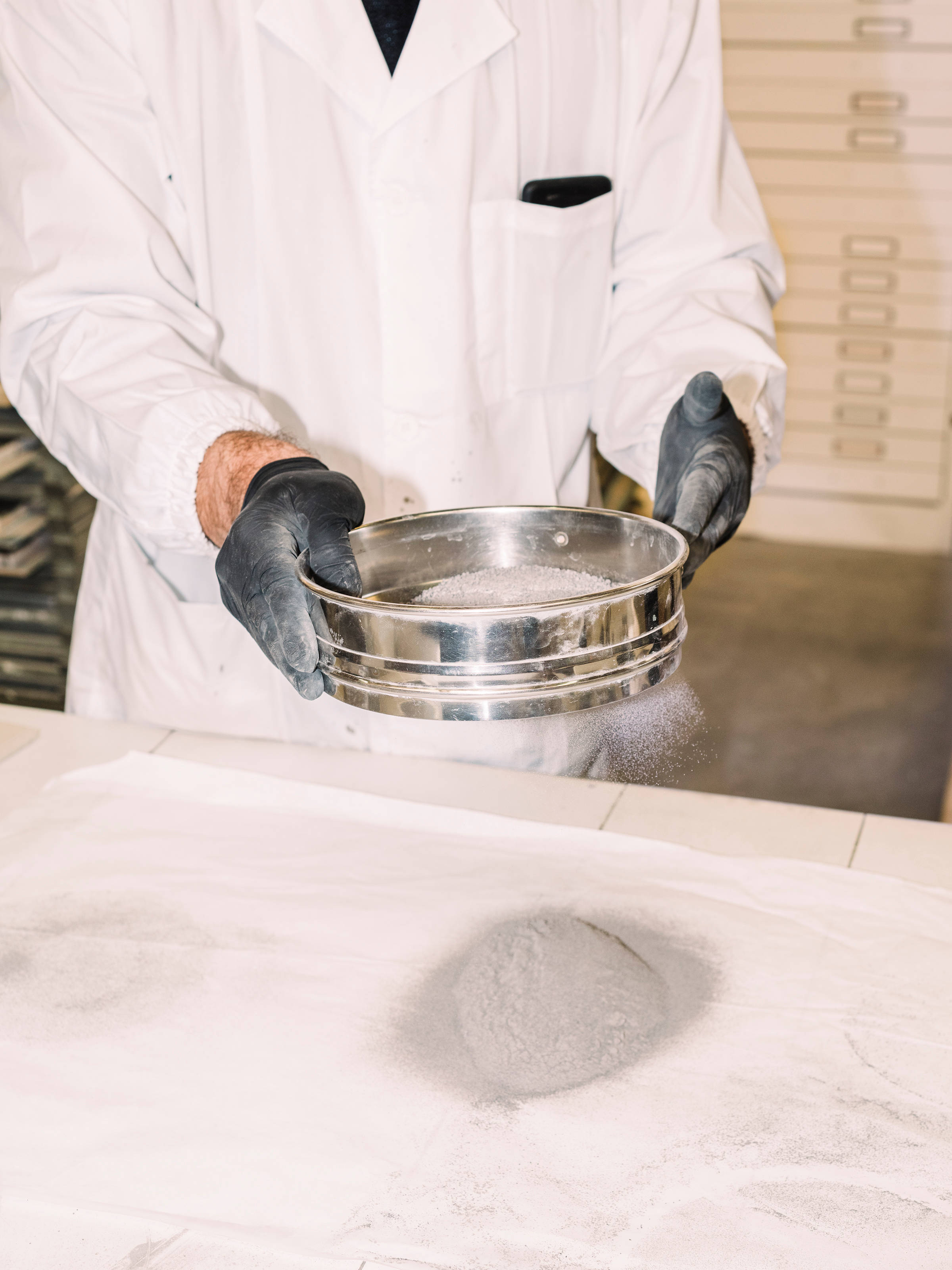 Sieving the volcanic ash into different particles for glaze production. 